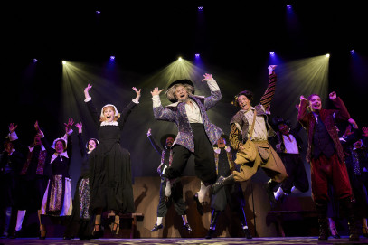 Women and men in costumes on stage