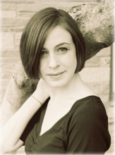 A sepia photograph of a woman with straight, dark chin-length hair. 