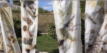 Four pieces of fabric hanging vertically outdoors